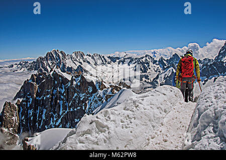 Close-up di scalatori camminando sul sentiero innevato in una giornata di sole a Aiguille du Midi, vicino a Chamonix. Una stazione sciistica ai piedi del Mont Blanc nelle Alpi francesi. Foto Stock