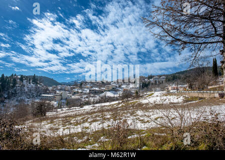 Montagna villaggio nevoso sotto cloudscape sul lago Plastira in Grecia centrale Foto Stock