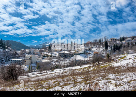 Montagna villaggio nevoso sotto cloudscape sul lago Plastira in Grecia centrale Foto Stock