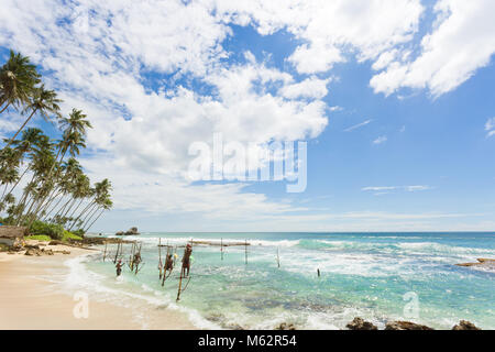 Koggala Beach, Sri Lanka, Asia - Dicembre 2015 - molti pescatori nativo a Koggala Beach praticando il modo tradizionale di pesca stilt Foto Stock