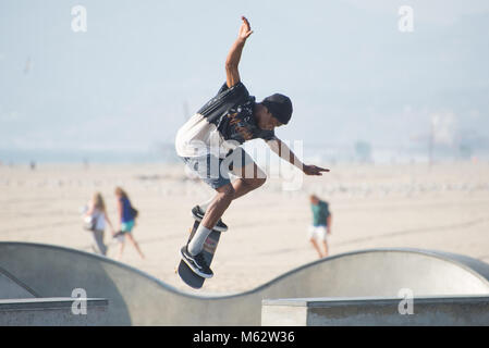 Un guidatore di skateboard di eseguire trick a Venice Beach Skatepark, Santa Monica, California, Foto Stock
