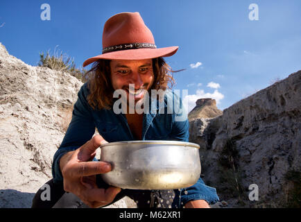 Oro Cowboy panner felice a trovare oro che riflette sul suo volto Foto Stock