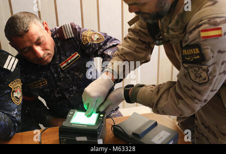 Un esercito spagnolo trainer cattura le impronte delle dita di un iracheno polizia federale degli stati assegnati al 2° Battaglione, quarta brigata, durante l'iscrizione presso la gamma Besmaya complessa, Iraq, Febbraio 8, 2018. Dal 2014, il funzionamento inerenti risolvere i deputati hanno costruito la capacità di base di più di 130.000 le forze di sicurezza irachene addestrati per sconfiggere ISIS entro le forze di sicurezza irachene, è giunto il momento di potenziare tali funzionalità per prevenire la ricomparsa di Iside e di creare stabilità entro la loro nazione. (Porzioni di questa immagine è stata offuscata per proteggere la sicurezza operativa) (U.S. Esercito Foto Stock