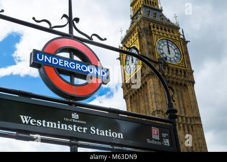 La stazione di Westminster segno della metropolitana con le case del Parlamento dietro. Foto Stock