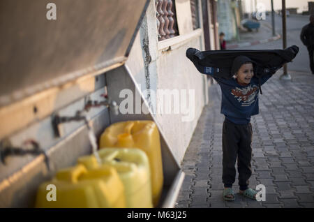 Febbraio 27, 2018 - Gaza City, la striscia di Gaza, Palestina - bambini palestinesi attendere per riempire le bottiglie con acqua potabile dai rubinetti pubblici presso l'al- Shati Refugee Camp nella striscia di Gaza, il 27 febbraio 2018. Situazione delle acque è stato deteriorato dal momento che Israele ha imposto un blocco sulla striscia di Gaza. (Credito Immagine: © Mahmoud Issa/Quds Net News via ZUMA filo) Foto Stock