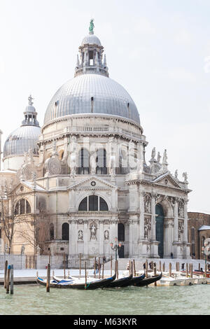 Venezia, Veneto, Italia, 28 Fenbruary 2018. Raro neve a Venezia causata dal clima Siberiano spazzamento anteriore Europa, vista della Basilica di Santa Maria della Salute e gondole attraccate dal Canal Grande. Foto Stock