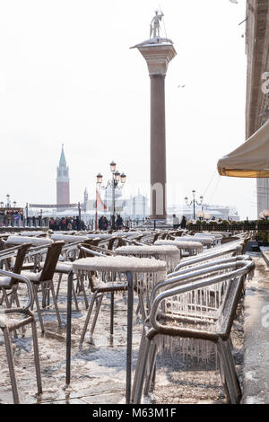 Venezia, Veneto, Italia, 28 Fenbruary 2018. Raro neve a Venezia causata dal clima Siberiano spazzamento anteriore Europa, ghiaccioli e cristalli di ghiaccio su tavoli e sedie in Piazza San Marco di fronte al Cafe Chioggia. Foto Stock