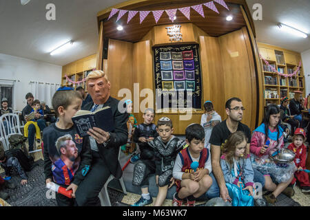 Elkana, Israele. 28 Feb, 2018. Purim holiday celebrazioni, Elkana, Israele. Febbraio 28th, 2018. Un uomo con una maschera di briscola e altri personaggi in costume celebrare la festa ebraica di Purim. In questa vacanza ebrei traditionaly vestito in costumi, leggere la chiocciola di Esther, una storia su un anti-ebraica complotto fallito nell antica Persia e fare un racket ogni volta che il nome di Haman, l'antagonista principale, è menzionato. Credito: Yagil Henkin/Alamy Live News Foto Stock