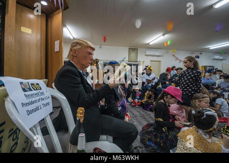 Elkana, Israele. 28 Feb, 2018. Purim holiday celebrazioni, Elkana, Israele. Febbraio 28th, 2018.. Un uomo con una maschera di briscola e altri personaggi in costume celebrare la festa ebraica di Purim. In questa vacanza ebrei traditionaly vestito in costumi, leggere la chiocciola di Esther, una storia su un anti-ebraica complotto fallito nell antica Persia e fare un racket ogni volta che il nome di Haman, l'antagonista principale, è menzionato. Credito: Yagil Henkin/Alamy Live News Foto Stock