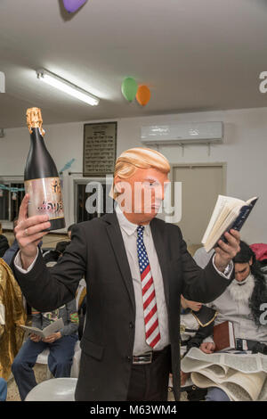 Elkana, Israele. 28 Feb, 2018. Purim holiday celebrazioni, Elkana, Israele. Febbraio 28th, 2018. Un uomo con una maschera di briscola e altri personaggi in costume celebrare la festa ebraica di Purim. In questa vacanza ebrei traditionaly vestito in costumi, leggere la chiocciola di Esther, una storia su un anti-ebraica complotto fallito nell antica Persia e fare un racket ogni volta che il nome di Haman, l'antagonista principale, è menzionato. Credito: Yagil Henkin/Alamy Live News Foto Stock