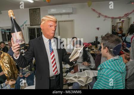 Elkana, Israele. 28 Feb, 2018. Purim holiday celebrazioni, Elkana, Israele. Febbraio 28th, 2018. Un uomo con una maschera di briscola e altri personaggi in costume celebrare la festa ebraica di Purim. In questa vacanza ebrei traditionaly vestito in costumi, leggere la chiocciola di Esther, una storia su un anti-ebraica complotto fallito nell antica Persia e fare un racket ogni volta che il nome di Haman, l'antagonista principale, è menzionato. Credito: Yagil Henkin/Alamy Live News Foto Stock