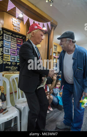 Elkana, Israele. 28 Feb, 2018. Purim holiday celebrazioni, Elkana, Israele. Febbraio 28th, 2018. Un uomo con una maschera di briscola e altri personaggi in costume celebrare la festa ebraica di Purim. In questa vacanza ebrei traditionaly vestito in costumi, leggere la chiocciola di Esther, una storia su un anti-ebraica complotto fallito nell antica Persia e fare un racket ogni volta che il nome di Haman, l'antagonista principale, è menzionato. Credito: Yagil Henkin/Alamy Live News Foto Stock