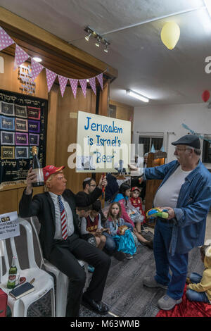 Elkana, Israele. 28 Feb, 2018. Purim holiday celebrazioni, Elkana, Israele. Febbraio 28th, 2018. Un uomo con una maschera di briscola e altri personaggi in costume celebrare la festa ebraica di Purim. (Lo slogan "Gerusalemme è Israele la "birra" è un gioco di parole sulla parola ebraica per la capitale, 'Beera'). In questa vacanza ebrei traditionaly vestito in costumi, leggere la chiocciola di Esther, una storia su un anti-ebraica complotto fallito nell antica Persia e fare un racket ogni volta che il nome di Haman, l'antagonista principale, è menzionato. Credito: Yagil Henkin/Alamy Live News Foto Stock