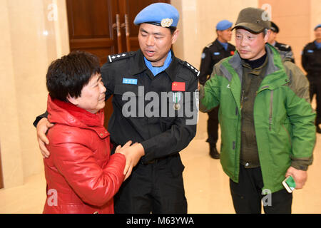 (180228) -- HANGZHOU, febbraio 28, 2018 (Xinhua) -- peacekeeper cinese Han Zhuoqi (C) è accolto dai suoi genitori al momento del suo arrivo a Hangzhou Aeroporto Internazionale di Xiaoshan di Hangzhou, a est della capitale cinese della Provincia di Zhejiang, 27 febbraio 2018, dopo lo svolgimento di un anno di missione nel sud Sudan. La sesta squadra cinese di polizia di pace per il sud Sudan, con sette membri tutti selezionati da Zhejiang, arrivati in Hangzhou martedì sera. In sud Sudan, i funzionari di polizia compie una varietà di attività nella capitale Juba e Wau, comprese le pattuglie dei campi profughi, aiuti umanitari e communi Foto Stock