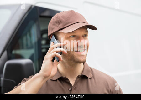 Close-up di un felice giovane uomo consegna parlando al telefono cellulare Foto Stock