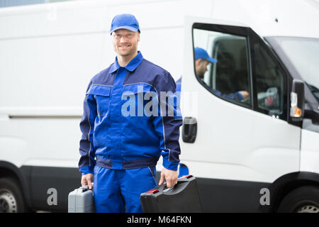 Ritratto di un giovane lavoratore di sesso maschile in uniforme blu Foto Stock