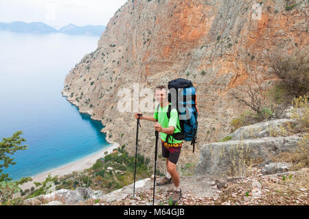 Atleta sulla sommità della roccia in montagna. Lo sport e la vita attiva di concetto Foto Stock