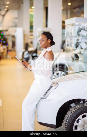 Femmina professionale addetto alle vendite che lavorano in concessionaria auto Foto Stock