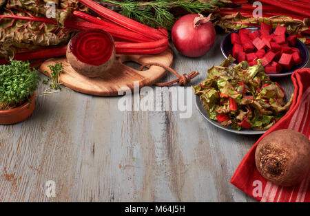 Sfondo di cibo con la barbabietola rossa radici e foglie di bietola, intero e taglio e di spazio per il tuo testo Foto Stock