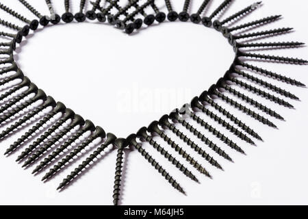 Photoset pattern arrangiati da viti nere isolato su uno sfondo bianco a forma di cerchio e un cuore Foto Stock