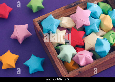 Origami colorati lucky stelle in una scatola di legno. Close up. Foto Stock