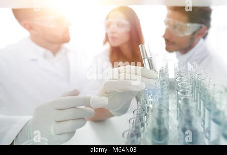 Immagine di sfondo è un gruppo di scienziati che studiano il liquido in Foto Stock