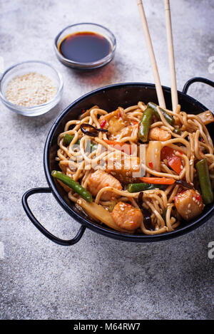 Friggere gli spaghetti con pollo, tofu e verdure. Foto Stock