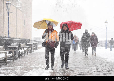 Le persone che camminano sulla neve vicino al Tower Bridge di Londra, come il più alto livello di avvertimento meteo è stato emesso per la Scozia e l'Irlanda come gli esperti avvertono di condizioni simili a Blizzard. Foto Stock
