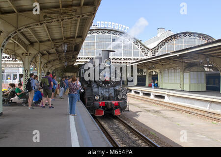 - San Pietroburgo, Russia - Luglio 10, 2016: Vitebsky stazione ferroviaria. Le persone scattano foto nelle vicinanze del carbone retro-locomotore sulla piattaforma Foto Stock