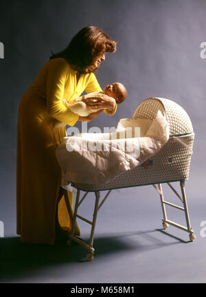 Anni Settanta madre indossa abito giallo mettere BABY BAMBINO DORMIRE IN TESSUTO BIANCO culla in vimini - KB12365 HAR001 HARS CORICARSI CAUCASIAN FIGLI GIOIA LIFESTYLE FEMMINE PARENTING STUDIO SHOT ROBE HOME VITA spazio copia di metà lunghezza figlie cura di vimini in interni nostalgia convivere 0-1 anni 20-25 anni 25-30 anni oggetto singolo felicità tutela mamme CULLA CULLA NEONATO CRESCITA CAREGIVER DI CONNESSIONE BABY BOY 1-6 mesi i ragazzi maschi MID-adulto metà donna adulta tessuti notturna BABY GIRL BASSINETTE etnia caucasica buona notte in vecchio stile mettendo a letto rimboccatura Foto Stock