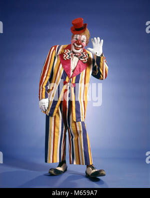 Anni Settanta felice sventolando CIRCUS CLOWN COLORATO STRIPED SUIT SMALL TOP HAT BIG bow tie scarpe divertente guardare fotocamera - kc6968 HAR001 HARS MID-adulto grande bow tie BIG TOP stolto scarpe divertenti JOKER guardando la telecamera di occupazioni in vecchio stile persone naso rosso piccolo top hat tuta a strisce salutando Foto Stock