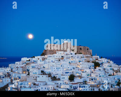 Chora di Astypalea in blu ora e la luna piena sorge dietro la Fortezza Foto Stock