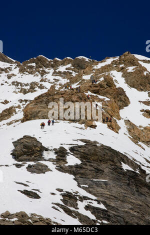 Close-up del sud pendenze superiori del Mönch, dal ghiacciaio Jungfraufirn, Svizzera, con diversi gruppi di scalatori in vista Foto Stock