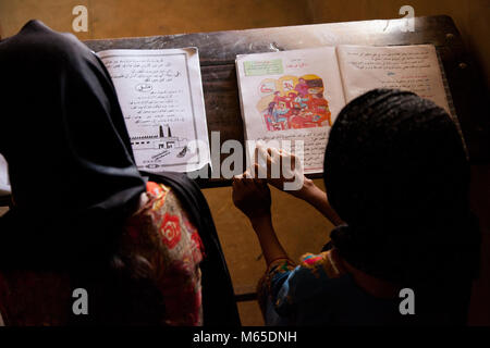 Le ragazze di lettura, istruzione nel governo pakistano scuole Foto Stock