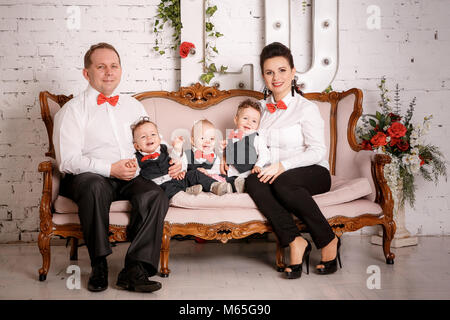 Grande famiglia felice: madre, padre, triplette figli Foto Stock