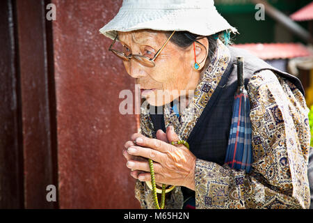 KATHMANDU, Nepal - 18 Maggio: donna non identificato con la sua mala talloni pregando in Bouddanath Stupa il 18 maggio 2013 a Kathmandu, Nepal. Foto Stock