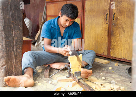 BHAKTAPUR, NEPAL-maggio 20: Unidentified carpenter segagione di un bordo in Bhaktapur, Nepal, il 20 maggio. 2013. Molto del Nepal dell'economia si basa ancora su mano troppo Foto Stock