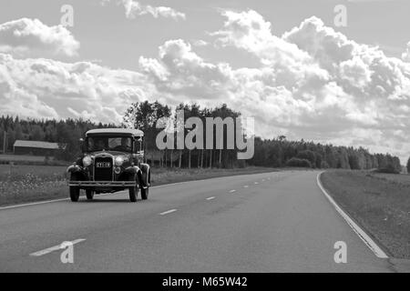 SOMERO, Finlandia - 5 agosto 2017: Ford Modello un auto classica si sposta lungo la strada rurale in estate, in bianco e nero foto vecchia look. Foto Stock