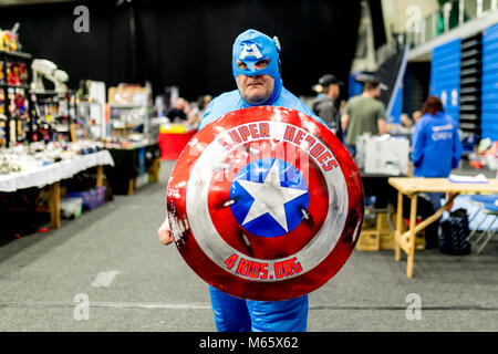 Uomo grasso divertente con costume da supereroe che funge da sovrumano con  poteri speciali ritratto sulla parete colorata