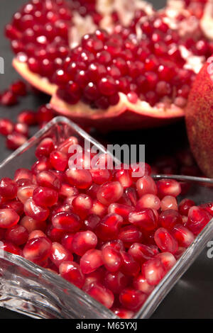 Vista ravvicinata della gustosa frutta pommegranate sulla parte superiore di una pietra ardesia. Foto Stock