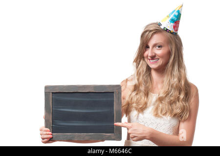 Bella ragazza felice in un cappuccio celebrativo con chalk board presso la festa. Compleanno celebrando concept Foto Stock