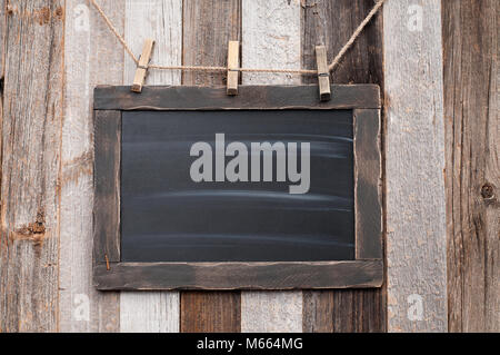 Chalk board appeso sul legno texture di sfondo Foto Stock