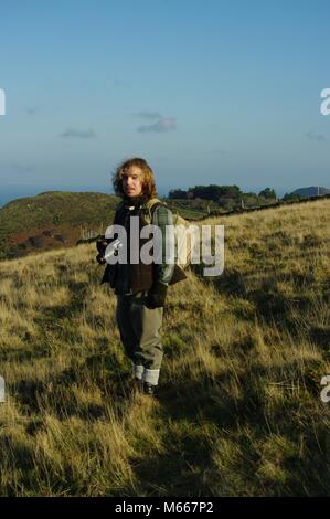 Coppia resistente bello Outdoorsman con lunghi capelli biondi di fotografare la Valle delle rocce, Parco Nazionale di Exmoor, North Devon, Regno Unito. Foto Stock