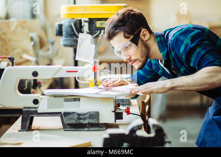 Carpenter impegnate nella lavorazione del legno alla segheria. Foto Stock