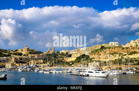 A Gozo, Malta. La seconda isola per dimensioni in Malta. La vista del porto con il vecchio cit e cattedrale nel retro. Il tramonto. Foto Stock