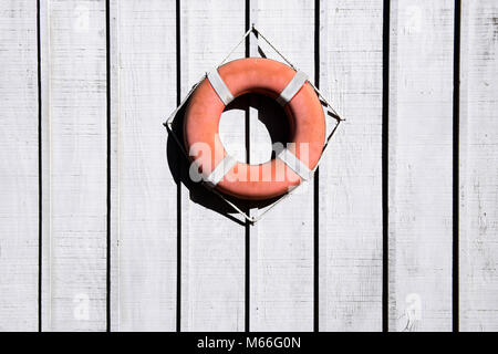 Salvagente appeso su una recinzione di legno Foto Stock