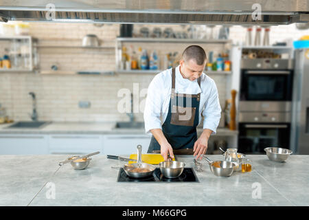 Focalizzato lo chef prepara una polenta in cucina del ristorante del processo di cottura Foto Stock