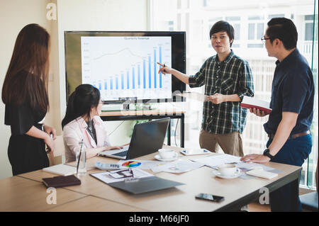 Asian imprenditrice discussione e scambio di idee con il giovane uomo freelance in sala riunioni. Business la società co-operare con esternalizzare il concetto di lavoratore. Foto Stock