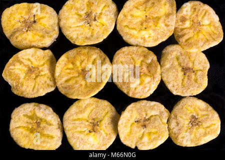 Banana cotta chips closeup su sfondo scuro Foto Stock