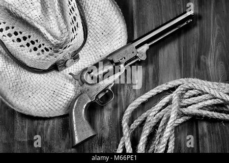 Vecchia pistola cowboy ,cappello di paglia e la corda in bianco e nero. Foto Stock